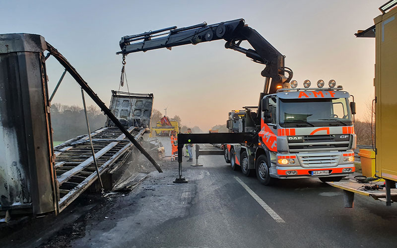 amf-abschleppdienst-bergungsdienst-3 Ein Ladekranfahrzeug von AMF hebt einen LKW-Anhänger auf einer Autobahn hoch.