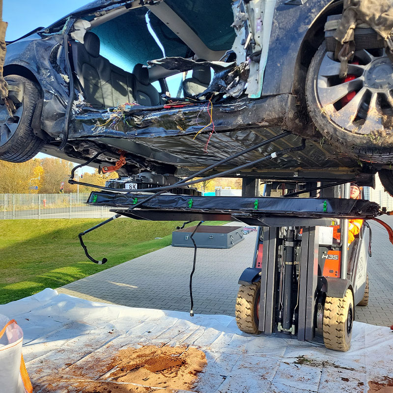amf-abschleppdienst-elektromobilitaet-1 Gabelstapler hebt ein zerstörtes Elektroauto auf dem Firmengelände von AMF hoch.